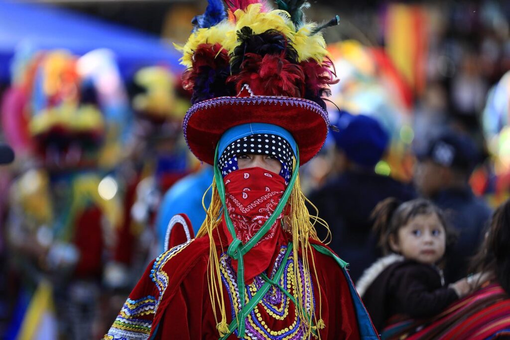  Danzante enmascarado durante una celebración tradicional en Guatemala, ataviado con colores y símbolos que forman parte de rituales ancestrales como el palo volador, expresión viva de la cosmovisión maya y del vínculo espiritual entre cielo y tierra